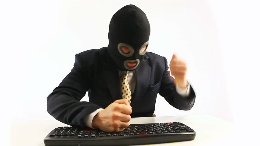 Guy in official suit and balaclava typing on keyboard