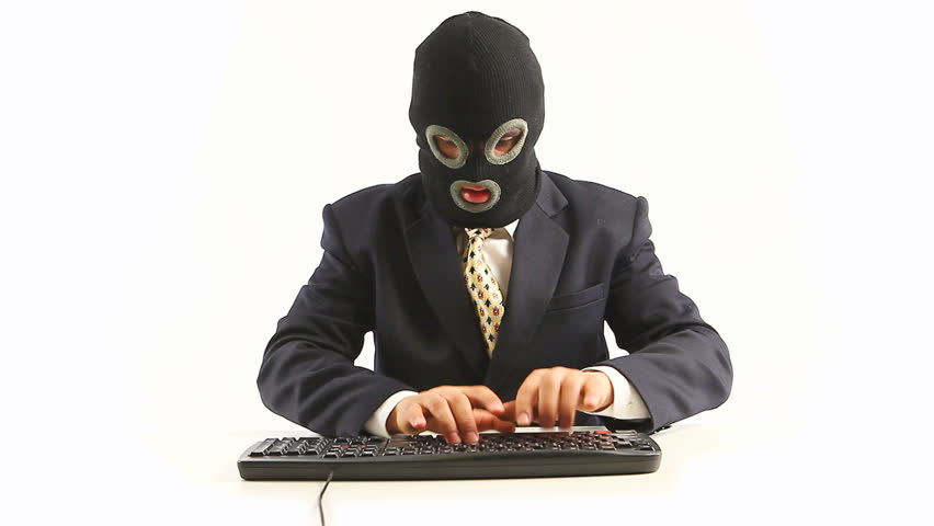 Guy in official suit and balaclava typing on keyboard