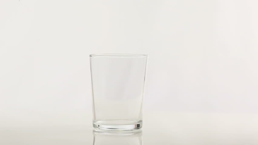 clear water pours from a plastic bottle into a glass