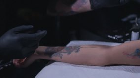 tattoo artist prepares the client's arm before applying the tattoo in slow motion.