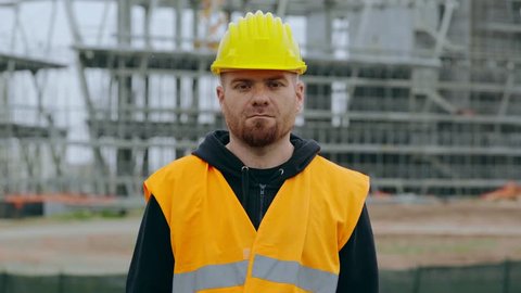 Serious construction worker crosses his arms and stares at the camera