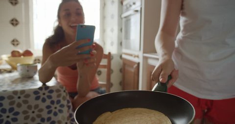 Best Friends making home made Pancakes girl taking photo using smart phone Lifestyle Woman at home sharing on social media