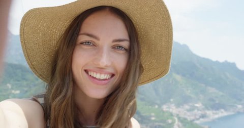 Young woman having video chat on holiday Happy Tourist girl waving at webcam on mobile phone camera sharing European summer travel vacation adventure in Amalfi Coast Italy