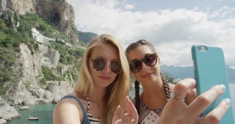Tourist Woman taking selfie photo with smart phone Best friends sharing moment photographing Amalfi Coast Italy on European summer vacation travel adventure