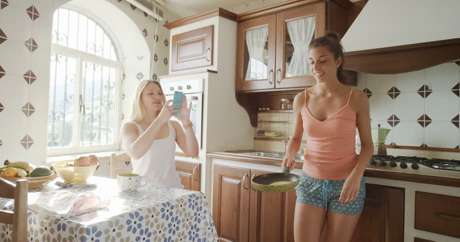 Best Friends making home made Pancakes girl taking photo using smart phone Lifestyle Woman at home sharing on social media Royalty-Free Stock Footage #24917468