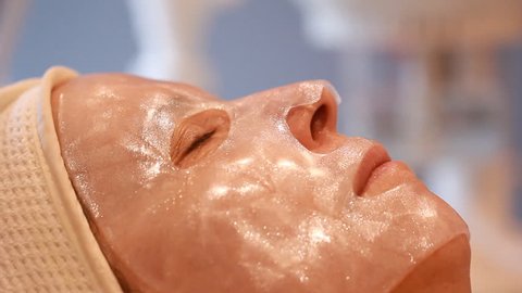 Woman getting a cosmetic peel off mask facial massage at spa salon skincare.

