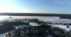 Bodom lake, Cinema 4k aerial landing view of a golf course and Bodom mansion, on a sunny and snowy winter day, in Espoo, Finland