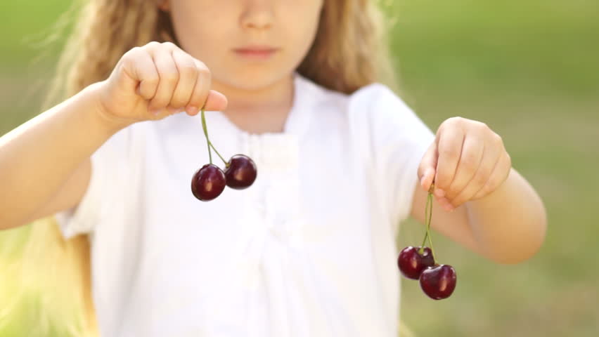 Girl playing with cherries.