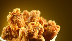 Rotation Bucket full of crispy kentucky fried chicken on brown background. 4K UHD video footage. Ultra high definition 3840X2160