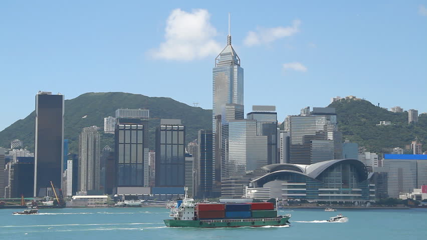 Small container ship crossing the victoria habour and city skyline, Hong Kong.