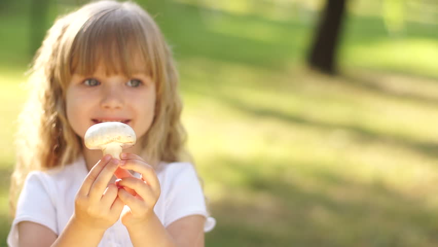 Portrait of a child holding a mushroom
