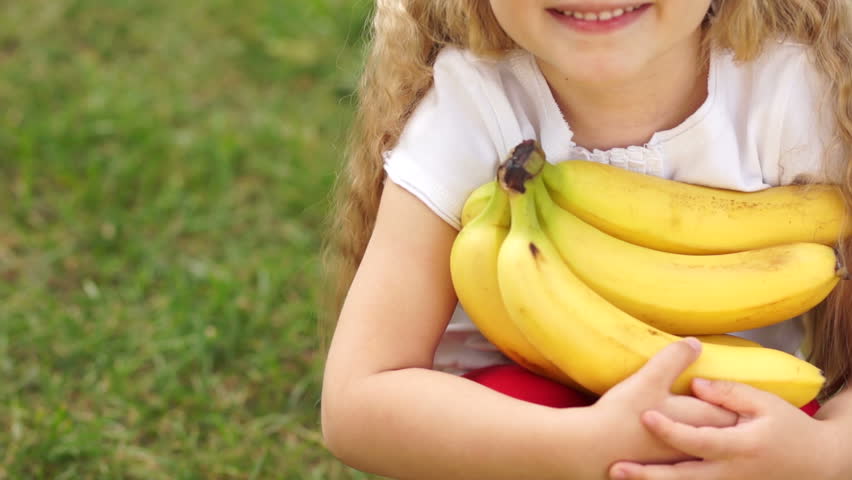 Child with bananas giving thumbs up