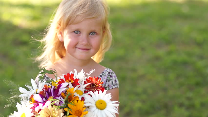 Little girl smelling a flower

