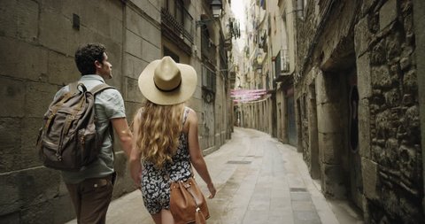 Rear view tourist woman Walking narrow streets of Barcelona Wearing cute summer dress enjoying European summer holiday travel vacation adventure