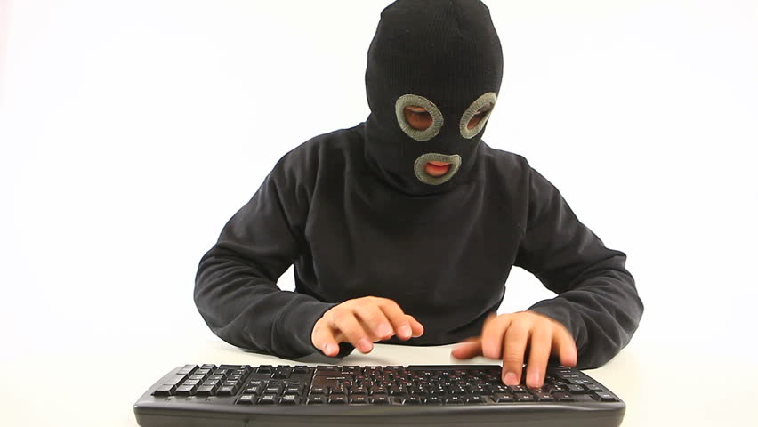 guy in balaclava mask starting to type something on the keyboard