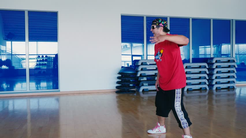 Smiling man dancing the hip-hop in front of mirror