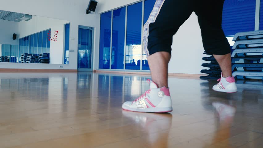 Close-up - the man in sneakers dancing in the gym