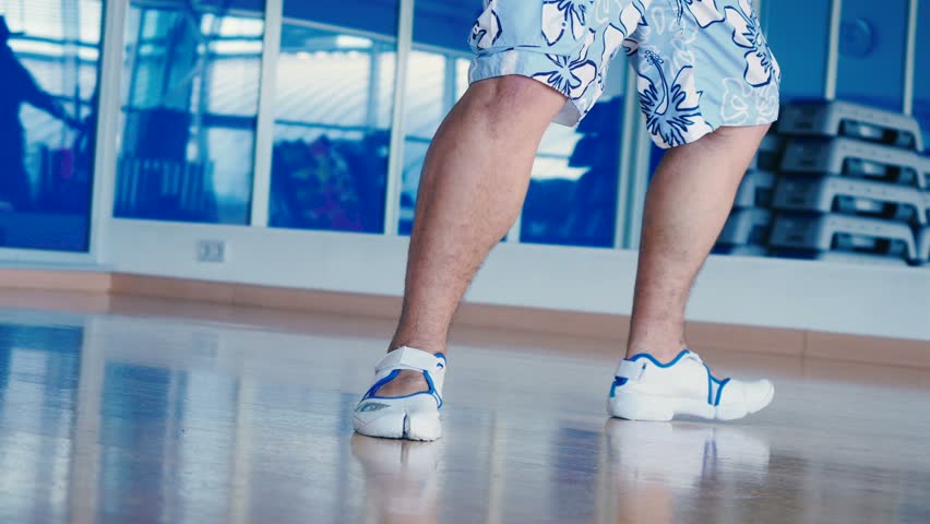 Close-up of man's legs dancing in gym
