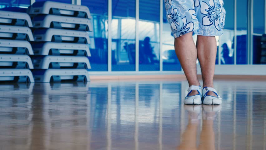 Close-up of man's legs in shorts dancing in gym