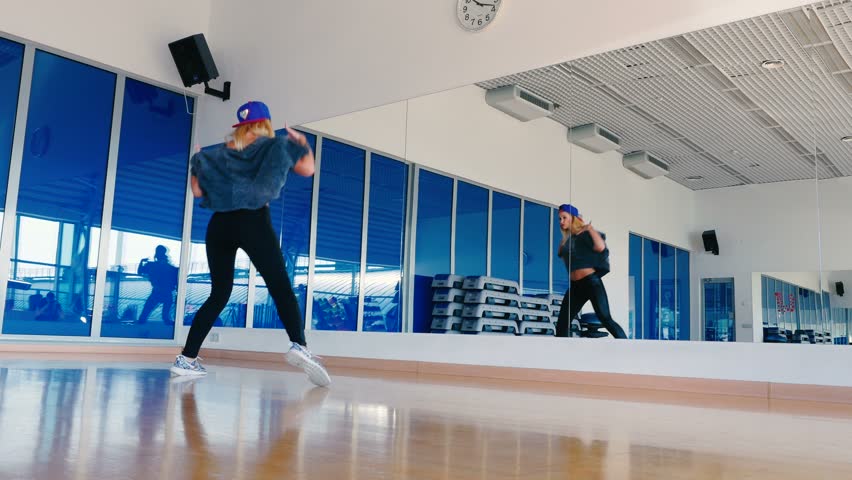 Plastic girl dancing the hip-hop in front of mirror