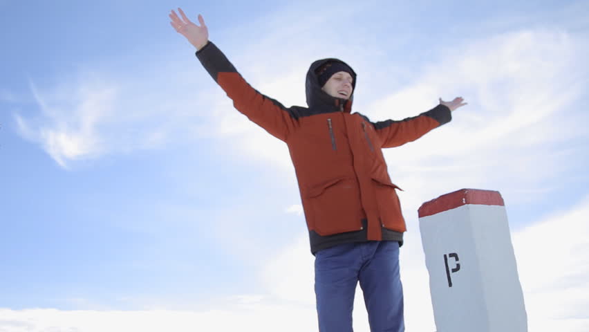 Happy young male hiker in white winter mountains, picturesque landscape