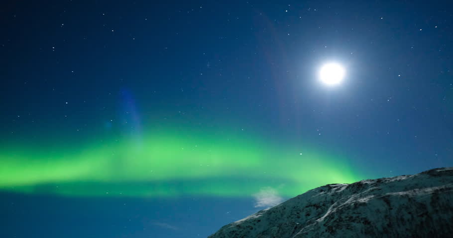 Northern Lights, polar light or Aurora Borealis in the night sky over Senja island in Northern Norway with trees and a snow covered mountain in the foreground. | Shutterstock HD Video #24951407