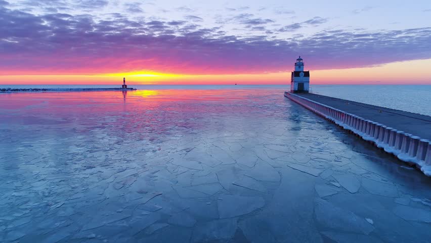 Flying toward amazing Lake Michigan sunrise with Lighthouse, aerial view.
