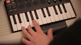 Man hand playing a MIDI controller keyboard synthesizer. Close up video full hd.