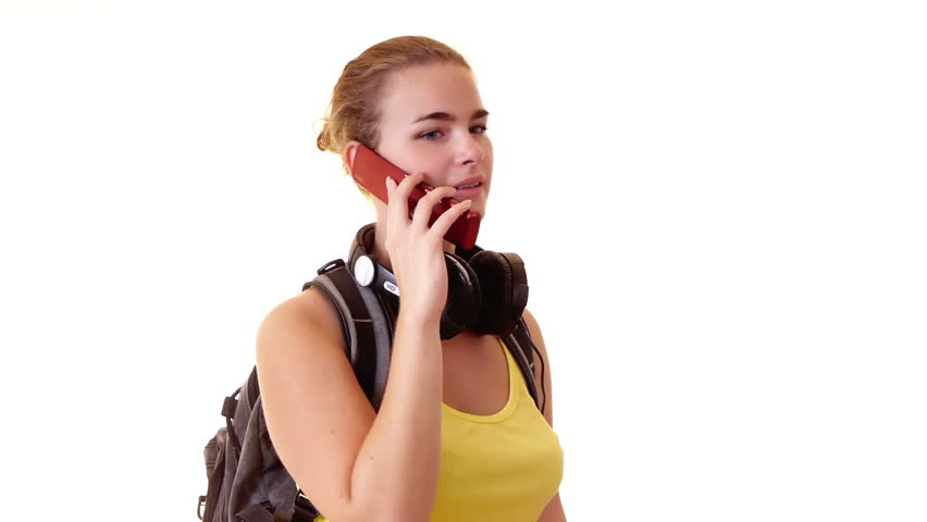 Pretty student with headphones and backpack calling by cellphone 
