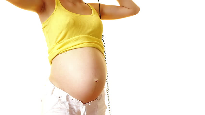 Woman putting headphones on her pregnant belly