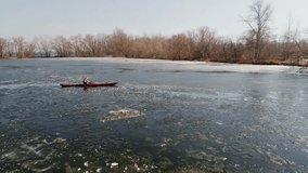 Aerial view of athlete rowing in a kayak. Winter. Ice. 