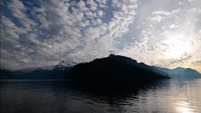 Evening landscape. Lake Lucerne in Switzerland. Cloudy sky. Grandiose view of the mountains in the sunset color. Time Lapse