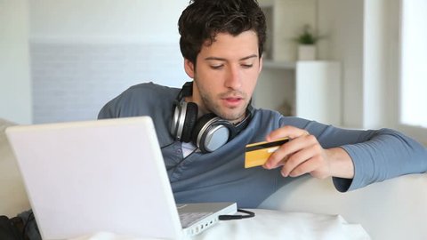Young man buying music on internet with tablet