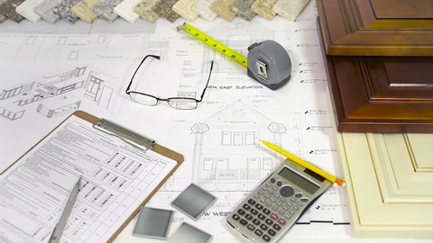 Remodeling material selection of home interior. Renovation planing of kitchen samples on desginer desk, kitchen, doors, floors, countertops. Design and blueprint on architects desk.