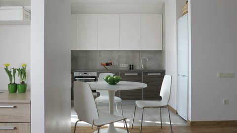 4K. Interior of modern apartment in scandinavian style with kitchen and workplace. Motion panoramic view.