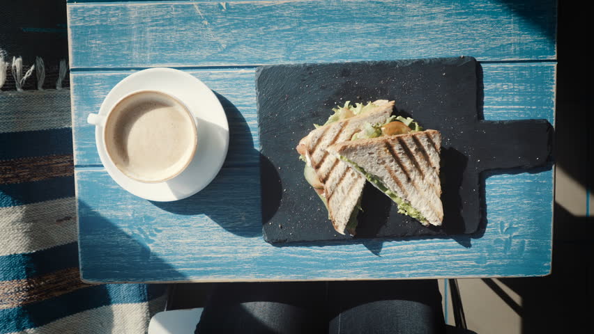 Young women eating hamburger or Sandwich in restaurant. Top view