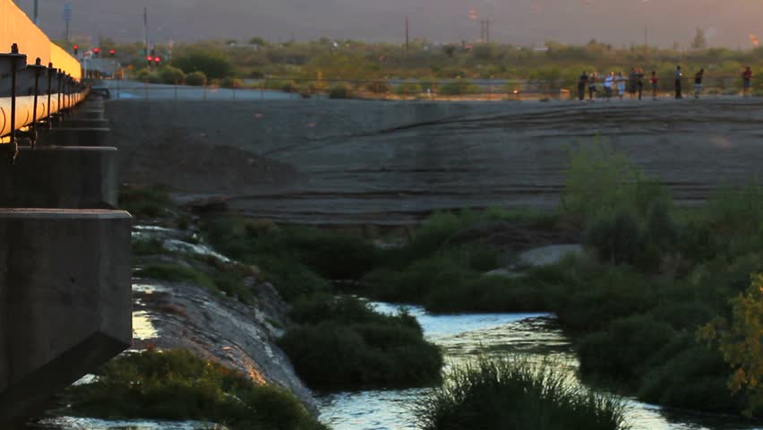 People gather to watch bats fly from under bridge, at sunset.1080p