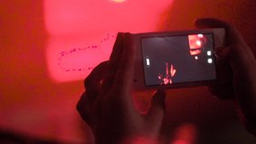 girl recording video with his smartphone to a concert
