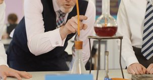 4k, Close-up shot of a teacher explaining an experiment to a high school chemistry class together. Slow motion.