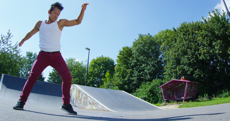 4K Young urban street dancer showing off some moves at skate park.