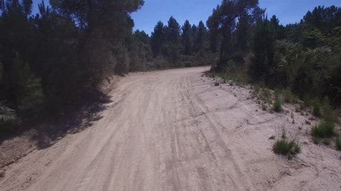 Low flying aerial of Subaru Rally car drifting around a corner with dust flying