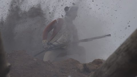 VIRGINIA - OCTOBER 2014 - Reenactment, large-scale, epic American Revolutionary War anniversary recreation -- in the middle of battle.  Explosions rock trenches, Brit Soldier killed by Patriot Musket