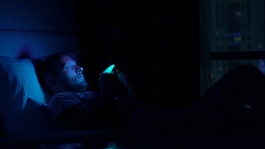 Man waking up and using smartphone on bed at home at night
 | Shutterstock HD Video #25030577