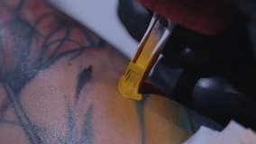 Professional tattoo artist makes a tattoo on a young girl's hand in slow motion. Tattoo artist make tattoo at the studio,close up