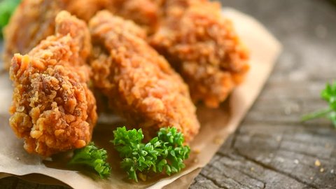 Rotation crispy fried chicken in a wooden table. Breaded Crispy fried kentucky chicken tasty dinner. 4K UHD video footage. Ultra high definition 3840X2160