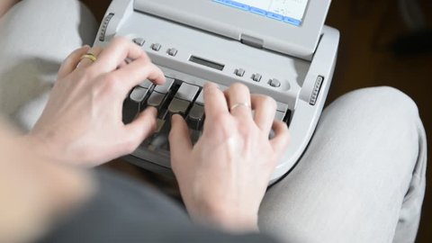 Overhead view of woman using stenography machine to record court proceedings