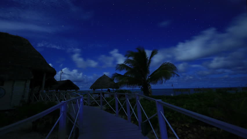Beach footpath with stars and clouds moving in night sky under moonlight, then stars become star trails developing into a spectacular circle around Polaris, the North Star