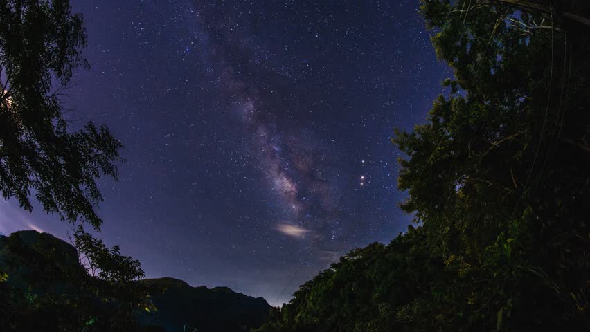 Milky way galaxy rises through the trees in Doi pha mee, Measai, Chiang Rai, Thailand.