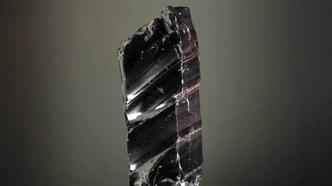 Raw obsidian stone mineral, spinning close-up 