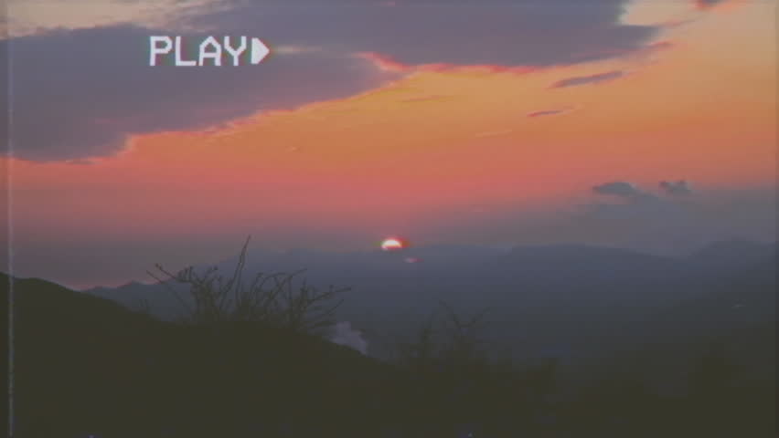 Fake VHS tape: timelapse of a romantic twilight on a mountain scenery. Highlands with snow-capped peaks.
